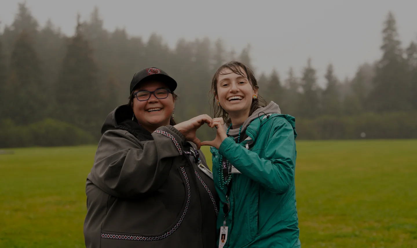 Two women forming a heart shape with their hands